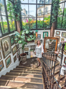 Standing on the iconic staircase at Pink Mamma, one of the most Instagrammable spots in Paris